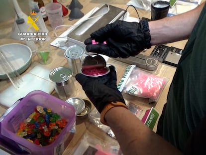 Un agente de la Guardia Civil inspecciona la droga que el grupo criminal distribuía en latas de conserva