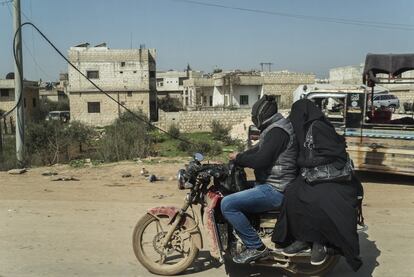 Un matrimonio se desplaza en una moto en la carretera entre Sarmada y la ciudad de Idlib. La provincia está controlada por el grupo yihadista HTS y muchas mujeres se cubren con el velo integral islamista.