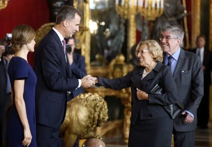 Los Reyes Felipe y Letizia saludan a la alcaldesa de Madrid, Manuela Carmena durante la recepción que han ofrecido en el Palacio Real a los representantes de las principales instituciones.