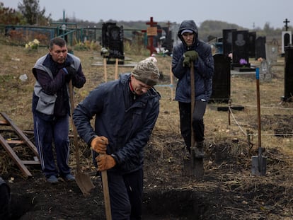 Local residents dig graves at the cemetery in the village of Hroza, near Kharkiv, October 7, 2023.