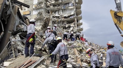 Personal rescate busca sobrevivientes entre los escombros del edificio.