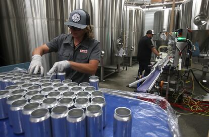 Una empleada de Can Van coloca latas de aluminio vacías en una cinta transportadora en San Carlos, California.