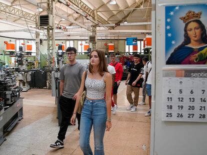 Sandra Montejano y otros estudiantes de Mecatrónica atraviesan el taller de mecanización de camino a un aula el jueves, el primer día de clases en los Salesianos de Atocha, en Madrid.