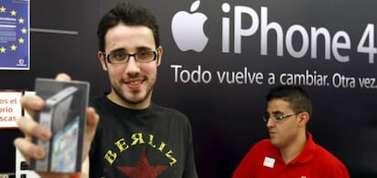 Uno de los primeros compradores del último móvil inteligente de Apple, el iPhone 4, posa con el dispositivo tras conseguirlo en una de las tiendas que han abierto esta medianoche en Madrid.