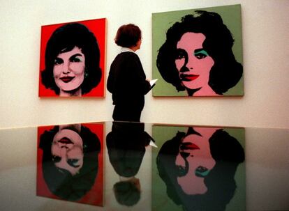 Una mujer mira los cuadros  'Red Jackie' (i) y 'Liz Taylor' , del artista  Andy Warhol dedicados a Jackie Kennedy y Elizabeth Taylor, en una exposición en el  'Kunsthalle' de Viena, el 3 de febrero de 1999.