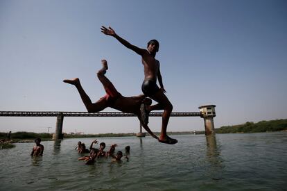 Niños saltan al río Sabarmati para refrescarse un día caluroso en Ahmedabad, India.
