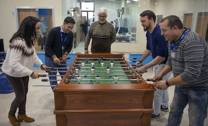 Unos empleados juegan al futbolín en una sala de ocio de la empresa.