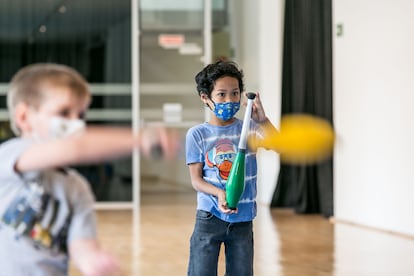 Varios niños aprenden a manipular mazas de malabares.