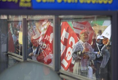 Manifestantes reflejados en unos escaparates durante la marcha del Primero de Mayo en Rieti, centro de Italia.