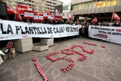 Empleados de Caja3 durante la asamblea celebrada en la calle, la primera tras el anuncio de 592 despidos, a la que han asistido alrededor de 2.000 personas, quienes, posteriormente, rodearon el edificio de la sede central de Ibercaja de Zaragoza para darle un "abrazo" simbólico.