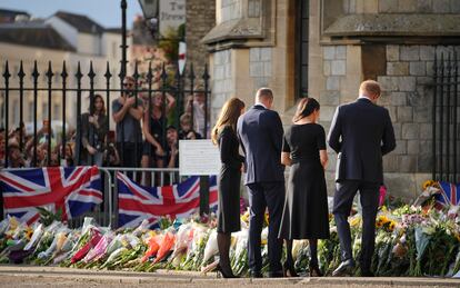 Los príncipes Guillermo y Enrique, junto a sus esposas, Kate y Meghan, miran las flores que los británicos han ido dejando en las verjas del castillo de Windsor. 