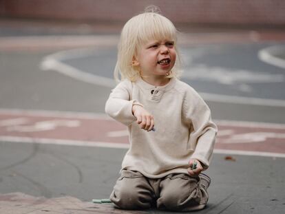 Un niño enfadado en el patio de un colegio.
