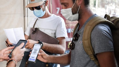 Dos ciudadanos muestran su certificado covid para acceder al cine este verano en París (Francia).