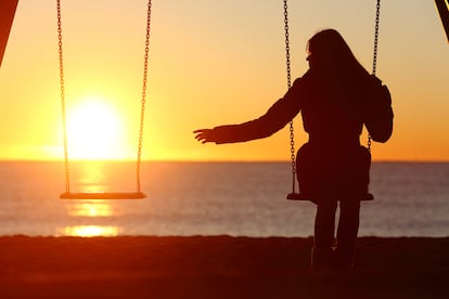 Una mujer se columpia en un atardecer.