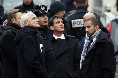 El primer ministro francés, Manuel Valls (en el centro de la imagen), también ha visitado la redacción de Charlie Hebdo.
