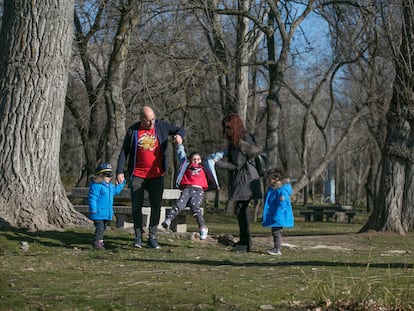 Óscar Hernández y Mónica García pasean y juegan con sus hijas y en el área recreativa La Chopera, de Manzanares el Real.