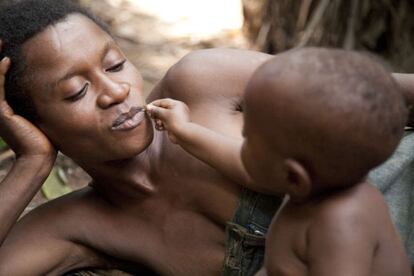 En las selvas pantanosas y los valles fluviales de la cuenca del Congo en ?frica, un ni?o pigmeo baka juega con su madre.  A los bebs bakas, como a otros ni?os tribales, se los tiene en brazos casi todo el tiempo.