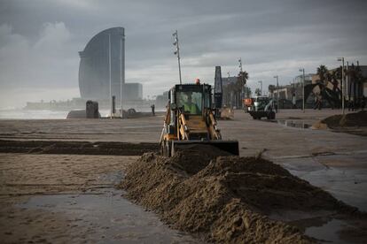 Una máquina apila la arena en la plaza del Mar de Barcelona, de fondo el hotel W (hotel vela).