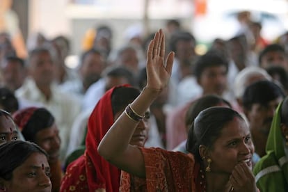 Una mujer levanta la mano para hablar en una reuni&oacute;n comunitaria en Aurangabad. 