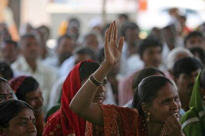 Una mujer levanta la mano para hablar en una reunión comunitaria en Aurangabad.