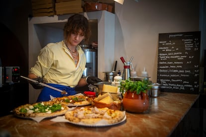 Argyelan finaliza tres pizzas recién salidas del horno. 