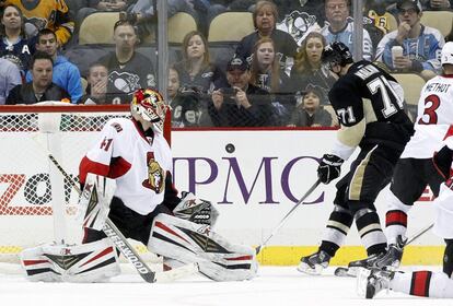 El portero Craig Anderson de los Ottawa Senators realiza un saque contra Evgeni Malkin de los Pittsburgh Penguins durante el tercer periodo del encuentro.