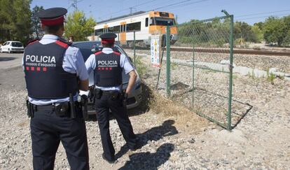 Dos Mossos d´Esquadra enfront el tren avariat entre L'Ametlla de Mar i L'Hospitalet de l'Infant.