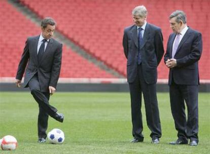 Sarkozy, a la izquierda, junto a Gordon Brown (derecha) y Arsène Wenger, entrenador del Arsenal, en el estadio del club londinense donde ha tenido lugar la cumbre.