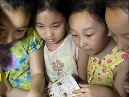 Un grupo de niñas chinas observa un cómic de Tintín durante una presentación en Pekín.