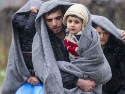 Migrantes caminan bajo la lluvia tras cruzar la frontera griega hacia Macedonia, cerca de la ciudad de Gevgelija. 