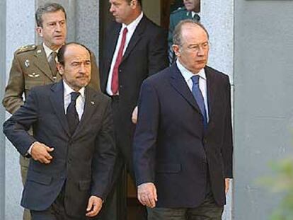 Rodrigo Rato sale de la capilla ardiente del comandante acompañado por Santiago López Valdivielso.