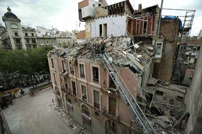 Los bomberos de la Generalitat trabajan en el desescombro de las plantas superiores del edificio en el que se produjo la explosión.