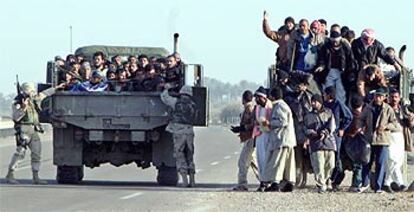 Decenas de prisioneros descienden de dos camiones militares estadounidenses, en el momento de ser liberados, ayer cerca de la localidad de Abu Graib, a 30 kilómetros de Bagdad.