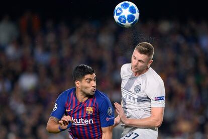 El jugador del Barcelona, Luis Suárez, y el jugador del Inter Milan Skriniar, luchan por cabecear un balón aéreo.