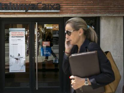 Una mujer pasa por delante de una oficina de Catalunya Caixa de Barcelona. 