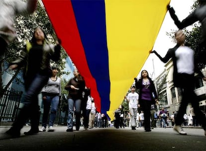 Los manifestantes sujetan una gran bandera colombiana durante la marcha en Bogotá.