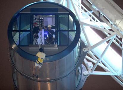 Un usuario baja auxiliado con un arnés de la cabina del Singapore Flyer