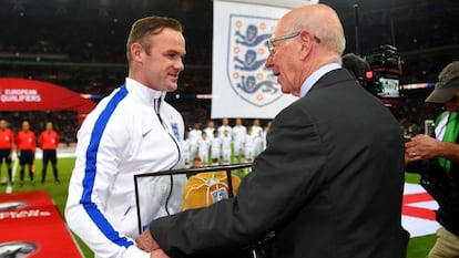 Charlton entrega una gorra dorada a Rooney por su centenario.