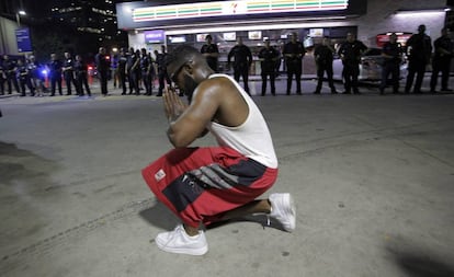 Un joven se arrodilla durante una manifestaci&oacute;n contra la violencia policial hacia los negros en EEUU, que se sald&oacute; con cinco agentes muertos en un tiroteo, en Dallas.