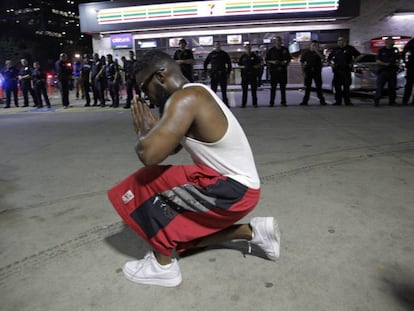 Un joven se arrodilla durante una manifestaci&oacute;n contra la violencia policial hacia los negros en EEUU, que se sald&oacute; con cinco agentes muertos en un tiroteo, en Dallas.