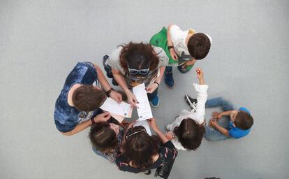 Varias personas comprueban sus papeletas antes de voyar el 28-A en un colegio público de Boadilla del Monte, Madrid.