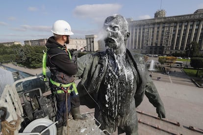 Un trabajador municipal limpia una estatua de Lenin durante las preparaciones para el aniversario de la Revolución Bolchevique de 1917 en San Petersburgo (Rusia).