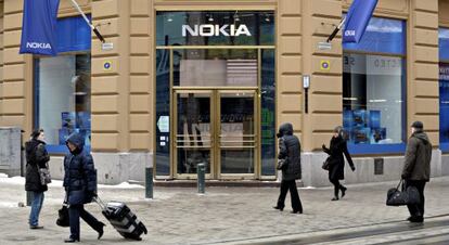 Varios viandantes pasan delante de una tienda que la fabricante de tel&eacute;fonos m&oacute;viles Nokia tiene en Helsinki.