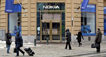 Varios viandantes pasan delante de una tienda que la fabricante de teléfonos móviles Nokia tiene en Helsinki.