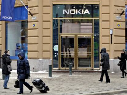 Varios viandantes pasan delante de una tienda que la fabricante de tel&eacute;fonos m&oacute;viles Nokia tiene en Helsinki.