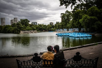 Una pareja toma un descanso frente al lago de Chapultepec, en Ciudad de Mxico.