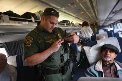 Un agente fronterizo revisa las identificaciones de pasajeros abordo de un tren de Chicago a Nueva York, en una fotografía de archivo. 