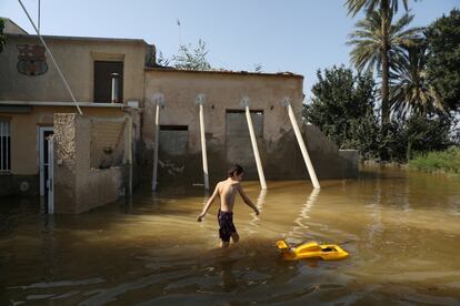 Un niño juega en el patio inundado de su casa de verano, después de las lluvias torrenciales en Dolores, cerca de Alicante.