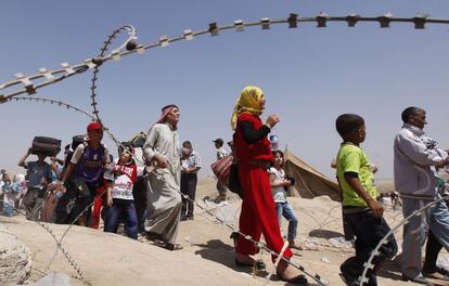 Un grupo de refugiados accede al paso fronterizo. 