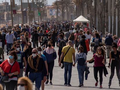 Cientos de personas caminan por el paseo marítimo de la Barceloneta, en Barcelona, este sábado.